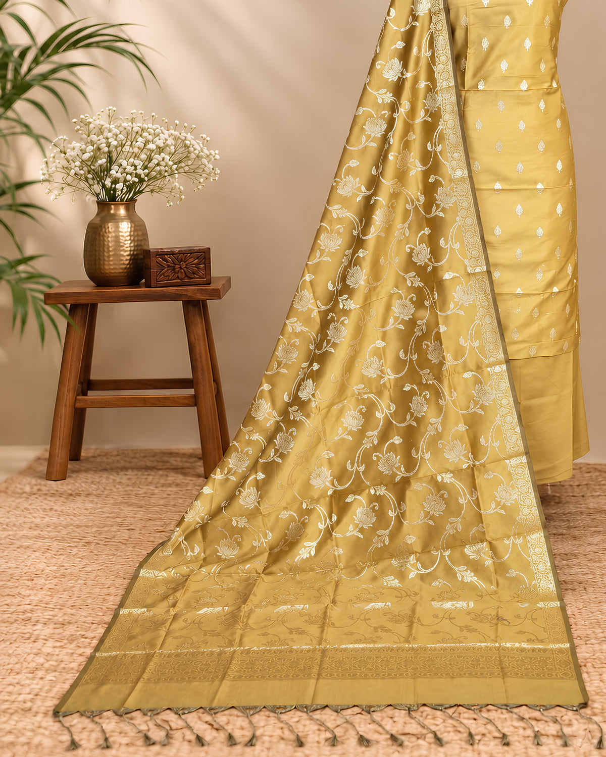 Mustard yellow silk butti fabric from S Fabs, showcasing smooth, shiny silk material with intricate butti patterns.